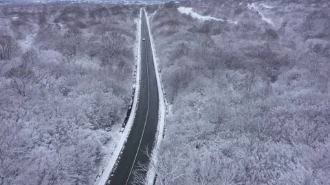 Aerial view to a mountain road cleared of snow in winter. Winter landscape 스톡 동영상 296534529