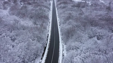 Aerial view to a mountain road cleared of snow in winter. Winter landscape 스톡 동영상 296534780