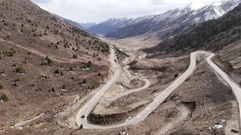 Aerial view of mountain road through dry highland terrain in China Stock Footage 337897404