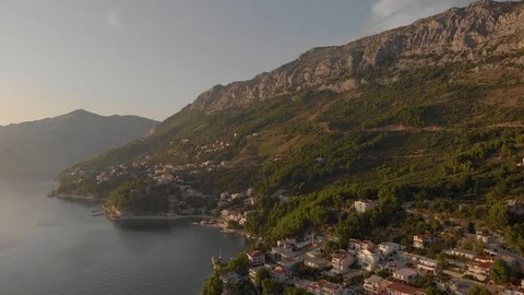 Aerial view of mountain shore of Adriatic Sea with coastal town and forest on it Stock Footage 126242598