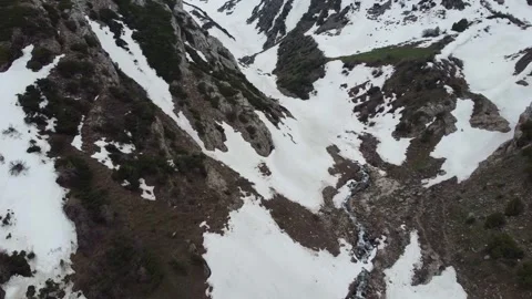 Aerial View of Mountain Stream Thawing Through Snow - Spring Reveal Stock Footage 331991296