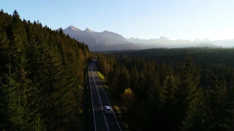Aerial view of mountain twisted road and luxury SUV car driving to the mountains Stock Footage