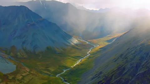 Aerial view of a mountain valley with river and sunbeams Stock Footage 337023595