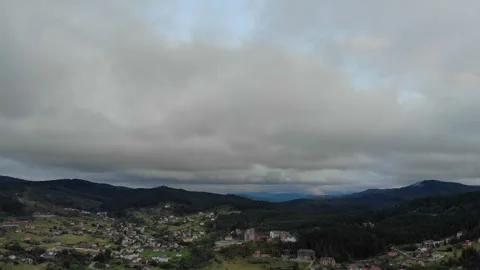 Aerial View Of Mountains, Forests, And City Beneath Cloudy Skies. Stock Footage 300380341