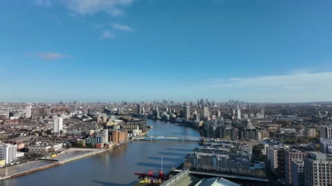 Aerial view moving along the River Thames toward London skyline Stock Footage 323680389