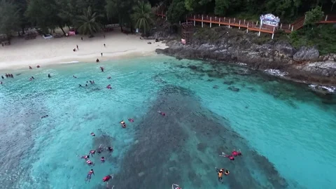 Aerial  view moving backward of people at the Taman Laut beach. Stock Footage 162644992