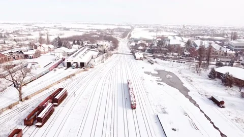 Aerial view of moving diesel train at the railway station covered with snow Stock Footage 149770992