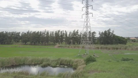 Aerial view moving up of high voltage electricity pylon in farmland Thailand Stock Footage 92110380