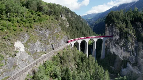 Aerial View of a Moving Red Train Along the Landwasser Viaduct in Swiss Alps Stock Footage 168147308