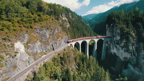Aerial View of a Moving Red Train Along the Landwasser Viaduct in Swiss Alps Stock Footage 169164612