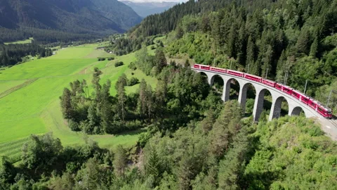 Aerial View of a Moving Red Train Along the Landwasser Viaduct in Swiss Alps Stock Footage 218160343