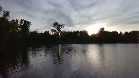 Aerial view moving slowly forward over the water at sundown Video stock 137245794