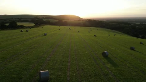 Aerial view moving west across a field towards the sunset, East Sussex, UK. Stock Footage 248783280