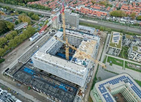 Aerial view of multi-building construction site with tower cranes Stock Photos