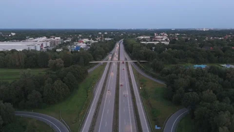 Aerial view of multi-lane Autobahn highway toward town at dusk Bremen Germany 動画素材 336812070