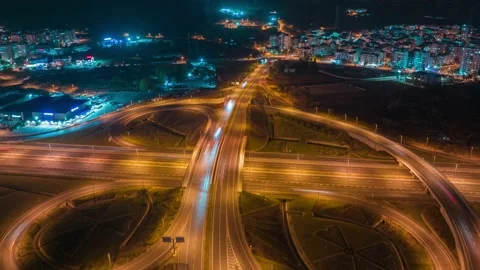 Aerial view of a multi-level stack interchange. Blue yellow neon light. Street Stock Footage 224140780