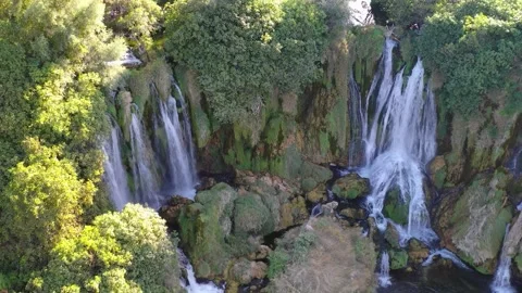 Aerial view of multi-stream waterfall cascading over mossy rocks in forest Stock Footage 324712010