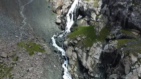 Aerial view of multi-tiered mountain waterfall cascading through rocky gorge Stock Footage 335078805