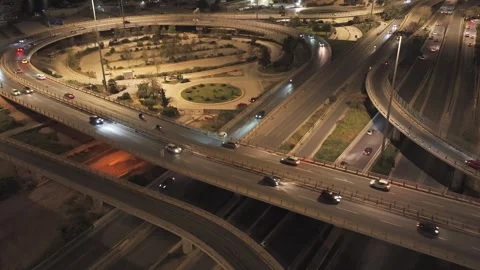 Aerial view of a multilevel highway interchange at night, with illuminated roads Stock Footage 333066896