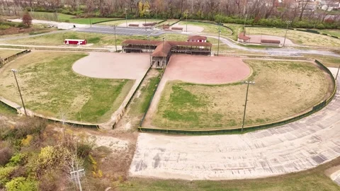 Aerial view of multiple baseball fields in late fall shows dirt infield and gras Vídeo Stock 300493835