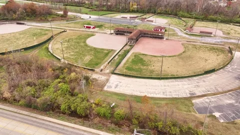 Aerial view of multiple baseball fields in late fall shows dirt infield and gras Stock-Footage 300494583