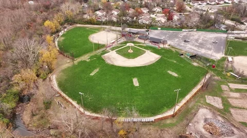 Aerial view of multiple baseball fields in late fall shows dirt infield and gras Stock Footage 300495345