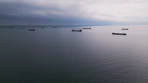 Aerial view of multiple cargo ships scattered across the calm open sea. The Video stock 300950955
