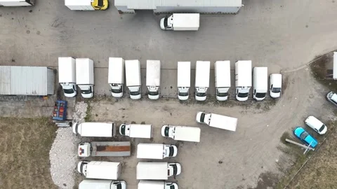 Aerial view of multiple delivery trucks arranged in a parking lot Stock Footage 331377954