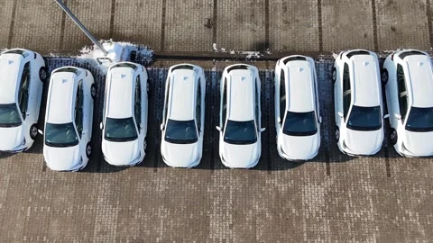Aerial view of multiple new white cars parked in a straight line Stock-Footage 331819600