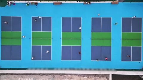 Aerial view of multiple pickleball courts with players in action. Colorful blue Stock Footage 311024733
