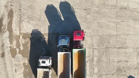 Aerial view of multiple trucks positioned on a construction site Видео 332277673