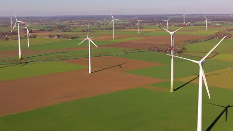 Aerial view of multiple wind turbines in rural green fields. High-angle Stock Footage 337563408
