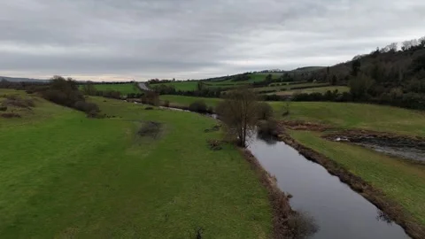 Aerial View of Narrow River Between Green Fields in Countryside Stock Footage 332738915