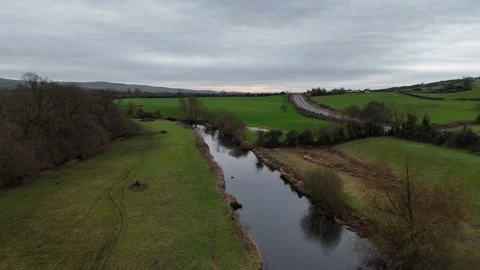 Aerial View of Narrow River Between Green Fields in Countryside 스톡 동영상 332738934