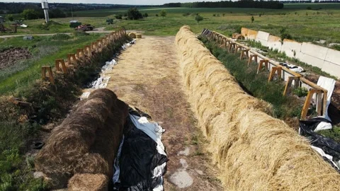 Aerial view of a nearby stack with many bales or rolls of straw in a field of Stock Footage 168118648