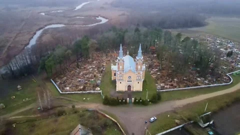 Aerial View of Neo Gothic Red Brick Church with Cemetery and Forest Stock Footage 316167866