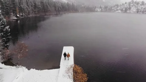Aerial View of Newly Engaged Interracial Couple Walking in Snow at Yosemite Stock Footage 146047997