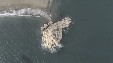 Aerial view of a nice sandy empty beach with a big nice rock in the ocean. Stock Footage 119056011