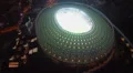 Aerial view of night city and large stadium, football match HD Footage