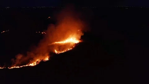 Aerial view. Night fire. On the field burning dry grass. 4K. Stock Footage 115492130