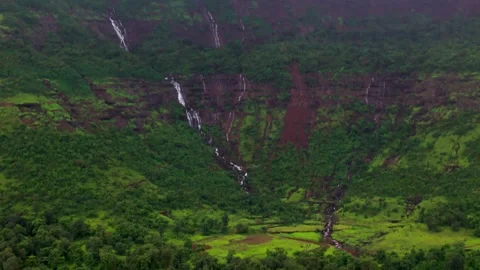 Aerial View of Numerous Small Waterfalls Cascading Through Lush Green Mountains Видео 342701600