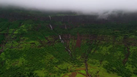 Aerial View of Numerous Small Waterfalls Cascading Through Lush Green Mountains Видео 342701603