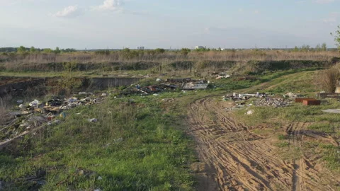 Aerial view  of a occasional garbage dump polluting the surrounding nature Stock Footage 107685585