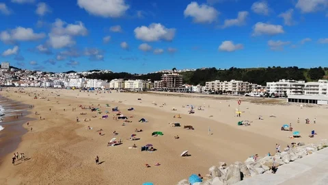 Aerial view ocean beach with waves and blue cloudy sky , Nazare , Portugal. Stock Footage 107599180