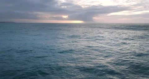 Aerial view of ocean during sunset. Drone flying over a sea surface in the Stock Footage 223007440