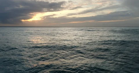 Aerial view of ocean during sunset. Drone flying over a sea surface in the Stock Footage 224910339