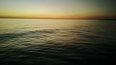 Aerial view of ocean during sunset. Drone flying over a sea surface in the Stock Footage 228995147