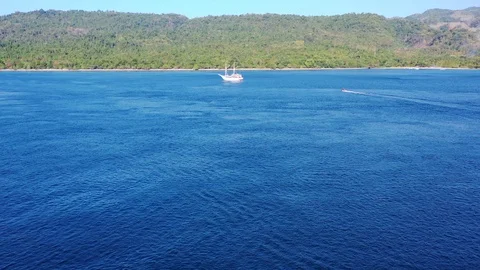 Aerial View of Ocean, Small Ship, and Tropical Island in Indonesia Stock Footage 121544060
