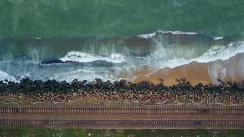 Aerial view of ocean wave reaching coast rocks with railway along the coastline Stock-Footage 124401312