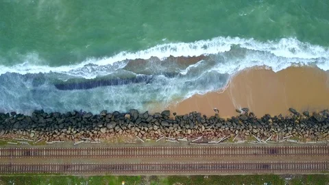 Aerial view of ocean wave reaching coast rocks with railway along the coastline Stock-Footage 124401342